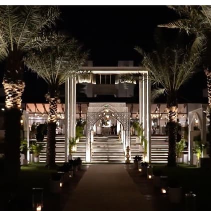 A palm-lined walkway lit at night at Raffles Al Areen Palace Bahrain