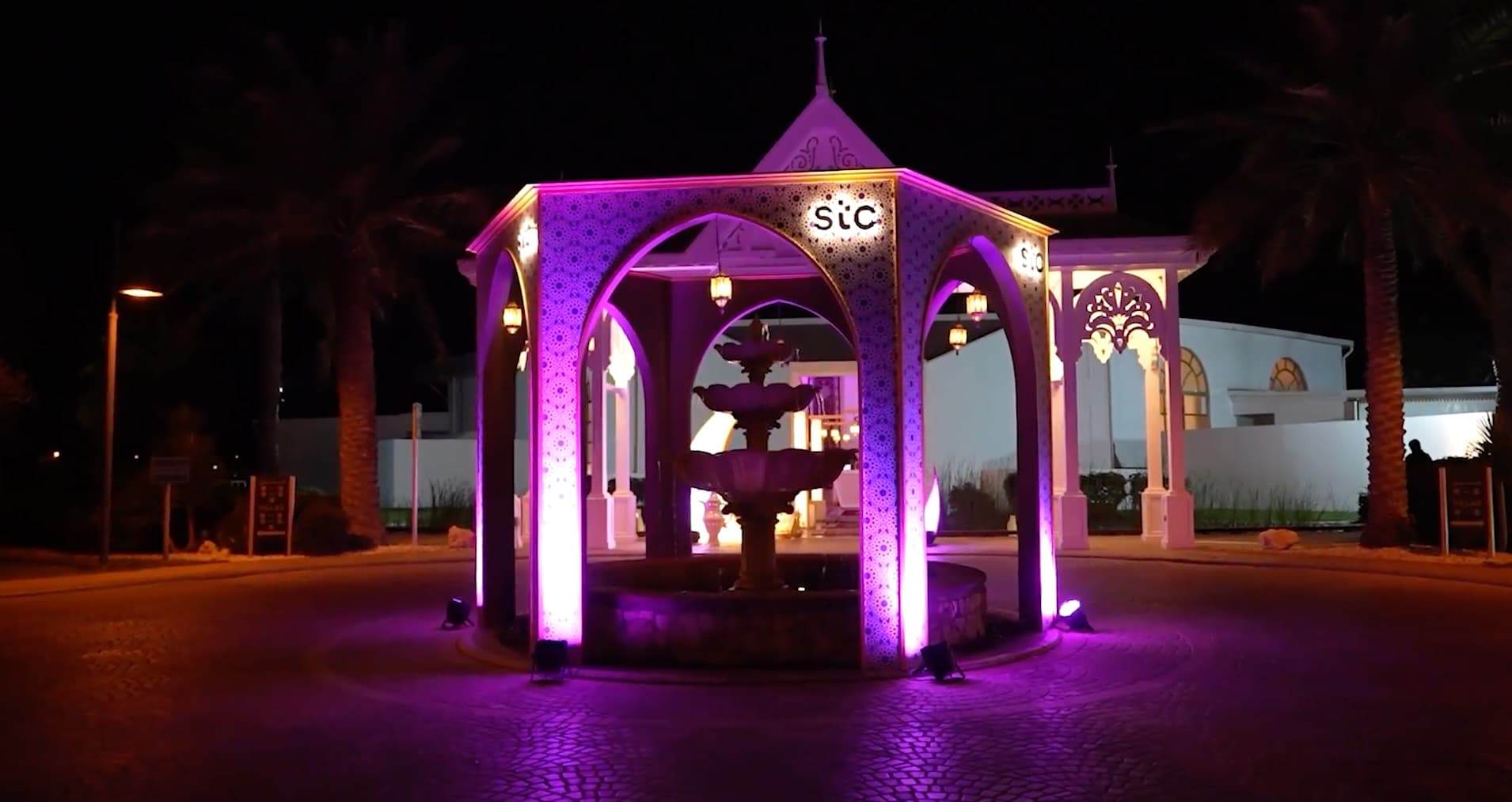 An stc gazebo lit purple at night in the gardens of The Ritz-Carlton