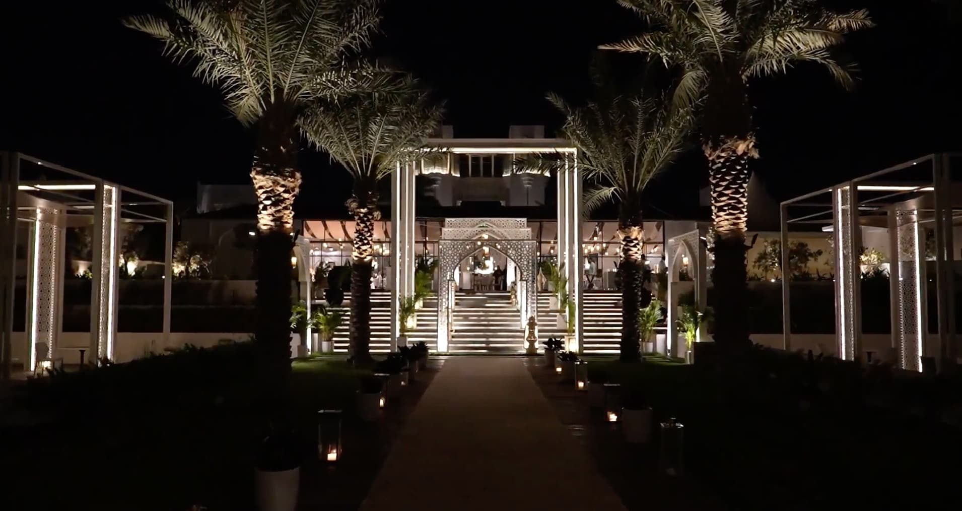 A palm-lined walkway lit at night at Raffles Al Areen Palace Bahrain